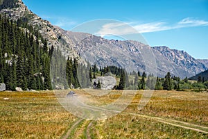 Offroad car is riding on gravel road. Overlanding concept. Kora river gorge in Kazakhstan, way to Burkhan bulak waterfall.