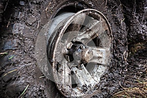 Offroad flat tyre and rim in mud close up