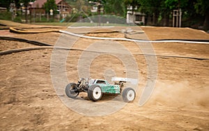 Offroad RC buggy driving on an outdoor dirt track