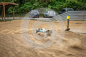 Offroad RC buggy driving on an outdoor dirt track