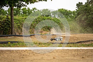 Offroad RC buggy driving on an outdoor dirt track