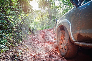 Offroad travel and driving concept, Wheel closeup in a countryside landscape with a muddy road, Off-road travel on muddy road