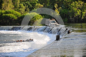 Offroad truck driving the Ivanhoe Crossing, Kununurra, Western Australia, Australia. A concrete causeway over Ord River photo