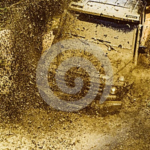 Offroad vehicle coming out of a mud hole hazard. Safari suv. Off-road travel on mountain road. Tracks on a muddy field