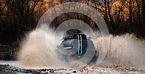 Offroading. Scene of wather splash in off-road racing. A car during a tough off-road competition diving in a muddy pool