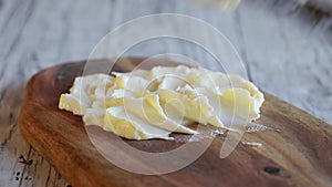 Offset spatula spreading butter onto a board in preparing a butterboar