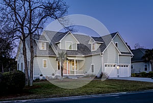 Offset view of beautiful luxury home at dusk with lights