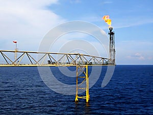 Offshore Flare stack of Gas Flare system on clouds in the blue sky