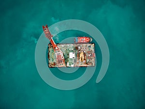 Offshore industrial platform or tower with crane or science sea research center, top or aerial view