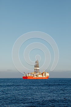 Offshore oil and gas drillship, blue sea background, aerial view