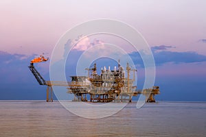 Offshore oil and rig platform in sunset or sunrise time. Construction of production process in the sea