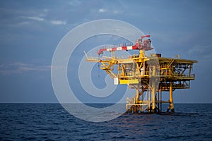 Offshore oil and rig platform in sunset or sunrise time. Construction of production process in the sea. Power energy of the world