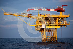 Offshore oil and rig platform in sunset or sunrise time. Construction of production process in the sea. Power energy of the world