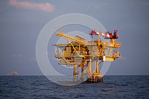 Offshore oil and rig platform in sunset or sunrise time. Construction of production process in the sea. Power energy of the world