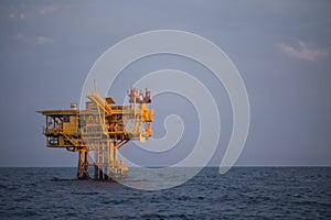 Offshore oil and rig platform in sunset or sunrise time. Construction of production process in the sea. Power energy of the world