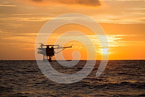 Offshore oil and rig platform in sunset or sunrise time. Construction of production process in the sea. Power energy of the world