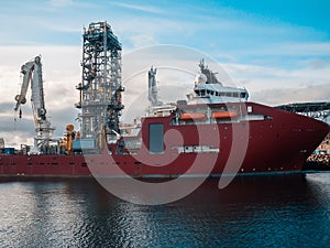 Offshore seismic vessel or ship for searching oil in port. Oil Rig and crane on background