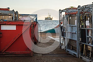 Offshore supply boat delivers cargo to oil rig platform