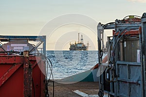 Offshore supply boat delivers cargo to oil rig platform