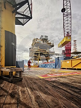 Offshore support vessel deliver cargo to oil platform at sea