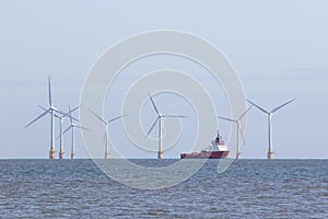 Offshore wind farm turbines with maintenance supply vessel ship photo