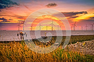 Offshore Wind Turbine in a Wind farm under construction off the England coast at sunset