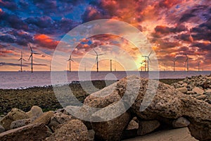 Offshore Wind Turbine in a Wind farm under construction off the England coast at sunset