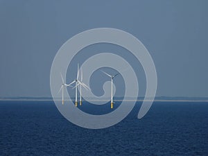 Offshore wind turbines in the sea. Renewable energy. Deep blue landscape with white towers with yellow bases. renewable energy.