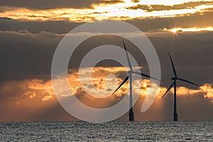 Offshore wind turbines at sunrise. Environmental concern and renewable energy