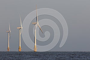 Offshore wind turbines. Windfarm on the sea horizon. Clean energy.