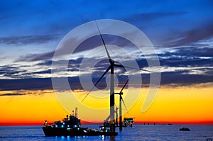 Offshore windfarm construction at sunset photo