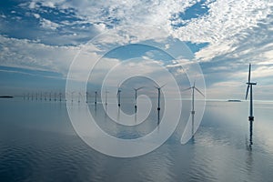 Offshore windmill park alternative energy. windmills in the sea with reflection in the morning, denmark