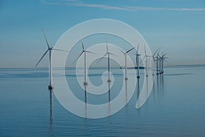 Offshore windmill park alternative energy. windmills in the sea with reflection in the morning, denmark