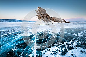 Ogoy island on winter Baikal lake with transparent blue ice