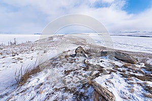 Ogoy island winter landscape. View of the mountains and frozen Lake Baikal on a winter day