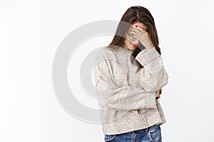 Oh gosh, embarrassing. Portrait of annoyed and fed up cute female in sweater and glasses making facepalm gesture looking