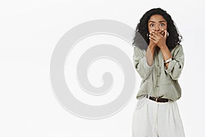 Oh gosh that terrible. Portrait of shocked and speechless concerned African American woman with curly hair gasping