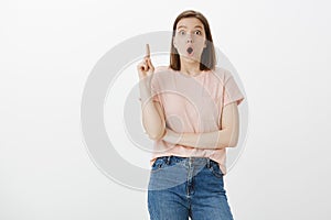 Oh I have idea. Portrait of excited attractive young european woman in pink t-shirt and jeans, raising index finger in