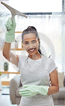 Oh look I can see you now. Shot of an attractive young woman standing alone at home and cleaning her windows.