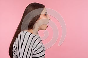 Oh my god, wow! Side view of surprised woman in striped sweatshirt standing with open mouth, expressing amazement