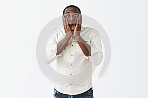 Oh my, what should I do. Portrait of shocked African American man in stupor, feeling nervous while overreacting and