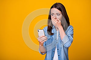 Oh no. Photo of attractive youngster lady hold telephone arm on mouth read blog negative comments unhappy terrified eyes