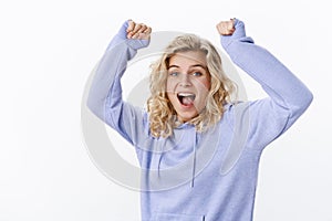 Oh yeah baby. Portrait of joyful and cheerful happy excited attractive woman with short fair hair and blue eyes yelling