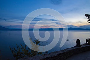 Ohrid lake panorama with woman and boat at sunet