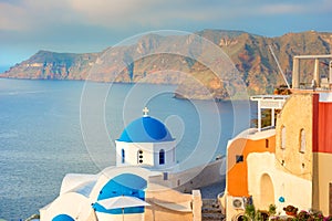 Oia town on Santorini island, Greece. Traditional and famous houses and churches with blue domes over the Caldera, Aegean sea.