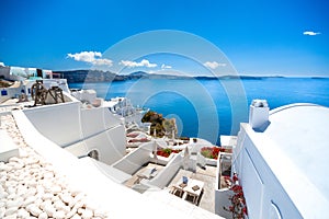 Oia town on Santorini island, Greece. Traditional and famous houses and churches with blue domes over the Caldera.