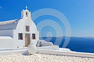 Oia town on Santorini island, Greece. White church and vase.