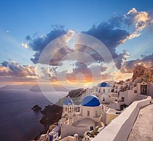 Oia village with churches against Aegean sea on Santorini island in Greece