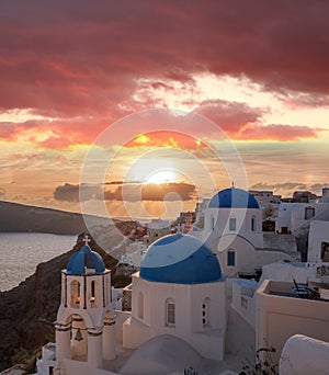 Oia village with churches against sunset on Santorini island in Greece