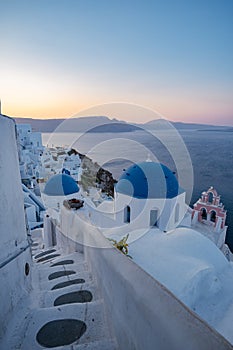 Oia village Santorini with blue domes and whitewashed house during sunset at the Island of Santorini Greece
